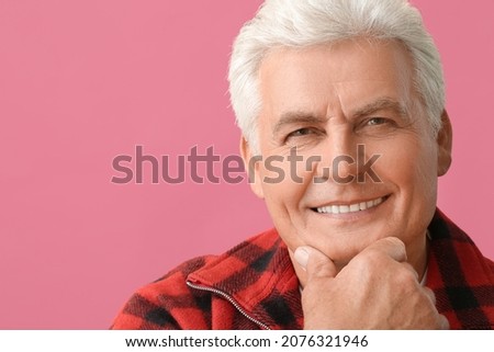 Stylish senior man on color background