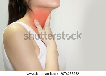 Asian woman using touch throat with pain, sore throat and sickness in inflaming. Royalty-Free Stock Photo #2076333982