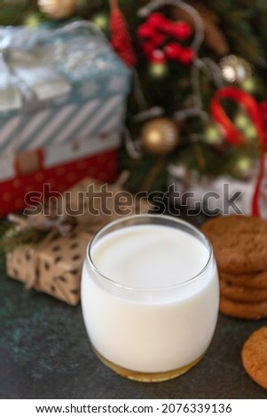 Homemade Cookies and milk for Santa Clause near the Christmas tree with present. Holiday concept. Copy space.