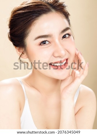 Asian woman with a beautiful face and fresh, smooth skin. Cute female model with natural makeup and sparkling eyes is posing on white isolated background. Royalty-Free Stock Photo #2076345049