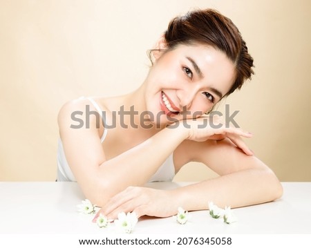 Asian woman with a beautiful face and fresh, smooth skin. Cute female model with natural makeup and sparkling eyes is posing on white isolated background. Royalty-Free Stock Photo #2076345058