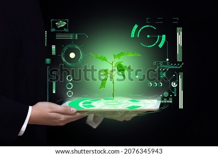 biotechnology science and medicine background, hands hold a tablet with a picture of green light plants and digital laboratory research