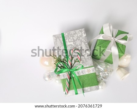 Two gifts wrapped in festive paper with colorful ribbons. Are decorated with vintage Christmas balls and bells.