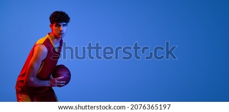 Flyer with professional basketball player posing with ball isolated on blue studio background in neon light. Competition, health, strength, sport, activity, achievements concepts. Copy space for ad