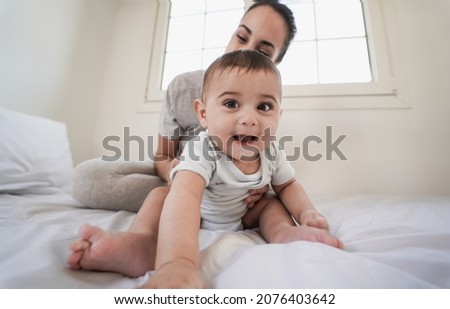 Loving mom having tender moments with toddler on bed at home