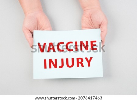 The words vaccine injury are standing on a paper, hands hold message, covid-19 vaccination, medical issue