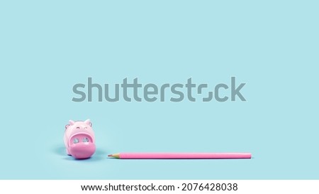 Pink pencil and piggy shaped sharpener on plain baby blue background. Minimal. Copy space