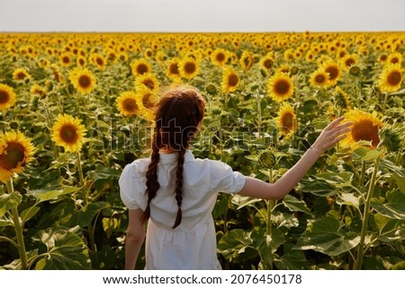 woman with two pigtails In a field with blooming sunflowers landscape