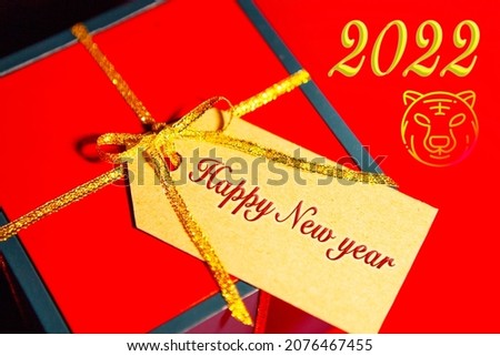 Red gift box with golden ribbon on a red background.