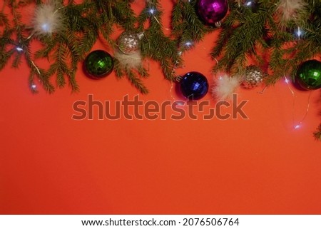 A beautiful Christmas card, a tree with New Year's decorations and a garland on a bright, red background.