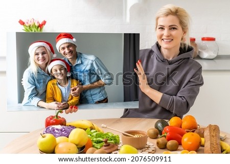 Photo printed on canvas, white background. Happy young family in Santa hats celebrating Christmas at home