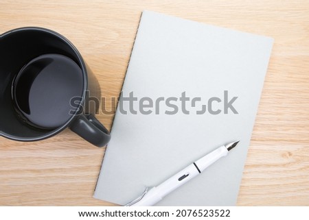 open notepad, cup of coffee, pen  on wooden background spiral notebook on table Business, planning, education, morning life working from home concept Top view Flat lay Mock up