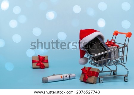 Basket with a glucometer on a colored background with backlight. Christmas concept of online shopping, pharmacies and sales plus gift. Close up, copy space