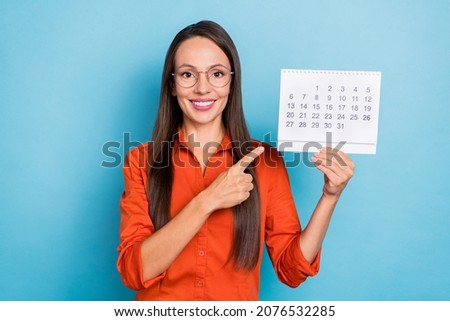 Photo of confident shiny young woman wear red shirt arm spectacles pointing finger date planner smiling isolated blue color background Royalty-Free Stock Photo #2076532285