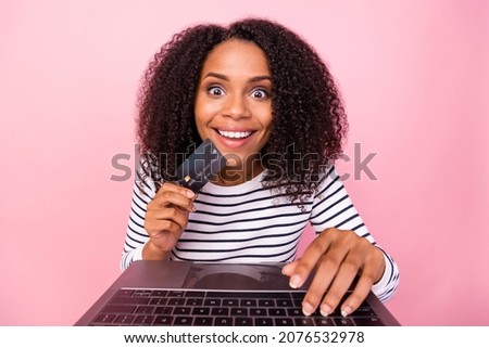 Photo of amazed excited girl hold debit plastic card beaming smile isolated on pink color background