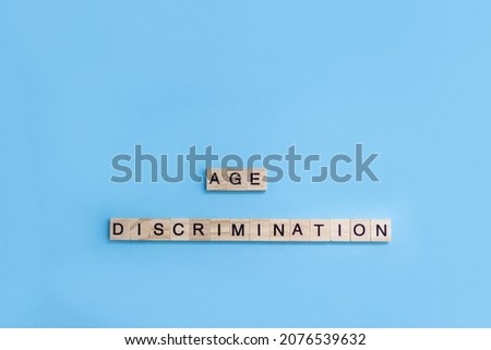 Words Age Discrimination. Wooden blocks with letters on blue background. Age equality concept. Copy space