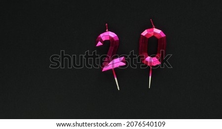 20, silver candles on dark background with glitters. Festive colorful background.