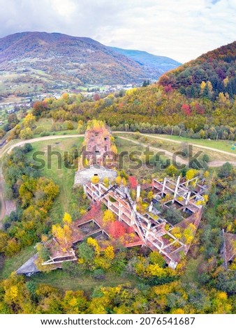 Ruins of a tourist hotel shelter in the Carpathians, Ukraine, autumn beech and coniferous forest, beautiful mountain landscape. Aerial view drone copter