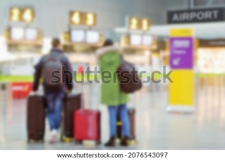 couple in airport waiting for boarding pass and to  check suitcases , image unfocused  for background