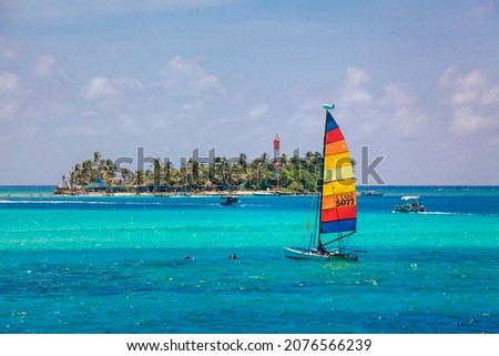 Small colorful sailboat sailing in the blue and transparent waters of the island of San Andres. Royalty-Free Stock Photo #2076566239