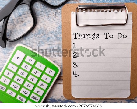 Calculator and glasses with text Things to do on a wooden background.