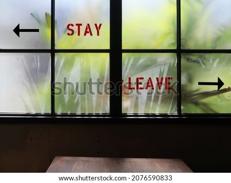 Room window with text sign way direction written STAY or LEAVE , concept of decision making to stay or go in relationship, friendship, job or life transition