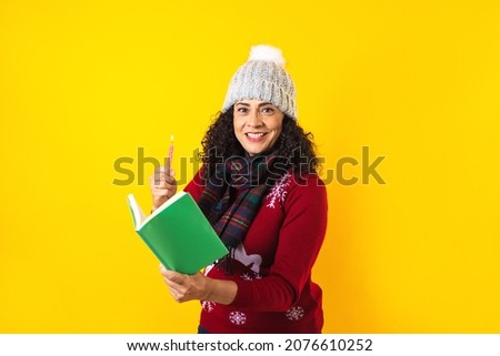 latin woman holding christmas candles and singing carols on yellow background in Mexico Latin America