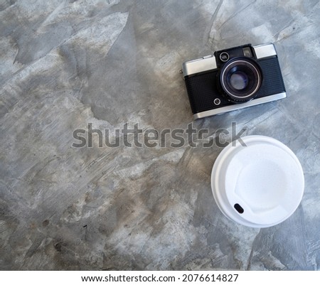 photo above white cup peper hot coffee ิblack Americano without sugar it is popular to drink in morning to help them stay awake  ready to work. and classic camera on a table cement pattern Loft color
