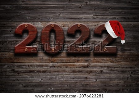 2022 Happy New Year seasonal background with real wood background. Aged parquet of pine wood for flyer, posters or invitations.Santa hat