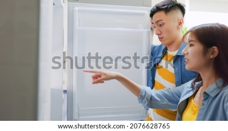 asian couple looking at empty shelf in fridge and they feel upset in kitchen at home Royalty-Free Stock Photo #2076628765