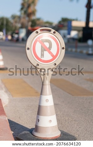 cone warning about a parking ban of automobile and cars. traffic safety sign on city street road. danger warning symbol on urban way for cars. control and regulate drive in town path