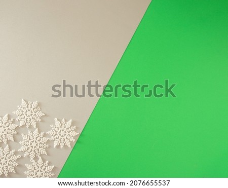 white frozen snowflakes on the table against green and grey background with copy space. retro minimalism