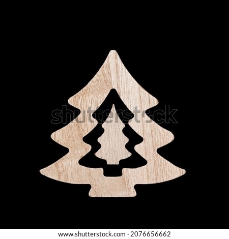 Decoration of the Christmas tree is isolated on a black background. Wooden Christmas tree