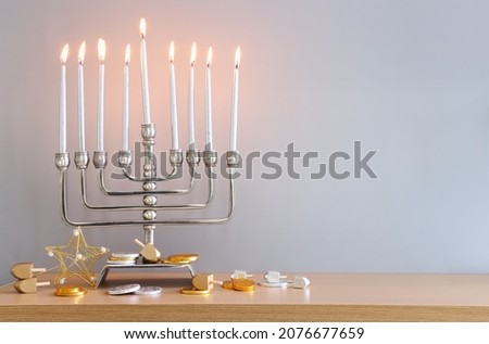 Religion image of jewish holiday Hanukkah background of spinning tops with letters that mean, A 
GREAT MIRACLE HAPPENED HERE, 
 and menorah (traditional candelabra) 