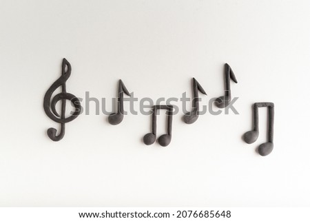 Black volumetric notes and violin key on white background top view. treble clef. Key of G Royalty-Free Stock Photo #2076685648