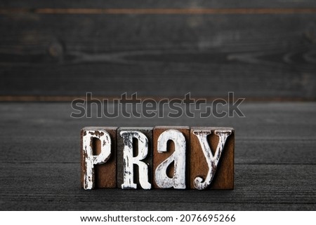 Pray. Faith, religion and the spiritual world concept. Text on a wooden background