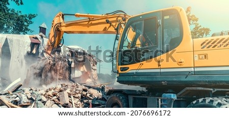 Excavator dismantling house on construction site. Demolition of dilapidated housing for new development Royalty-Free Stock Photo #2076696172