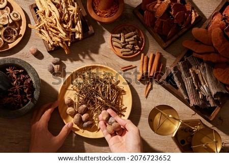 Traditional chinese medicine with herb and spices in brown wooden background mortar and pestile , for medicine advertising , photography traditional medicine content Royalty-Free Stock Photo #2076723652