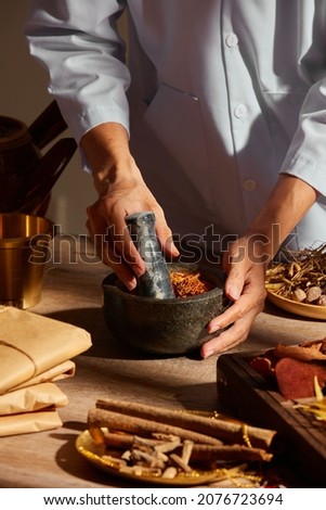 Traditional chinese medicine with herb and spices in brown wooden background doctor using mortar and pestle for advertising ,  traditional content 