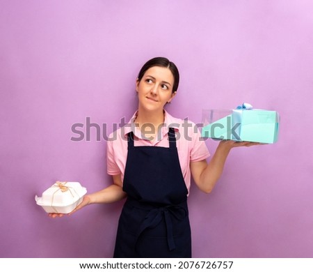 Woman holds box with bento cake in one hand, and an ordinary packaged product in other. Advertising of confectionery products, selection. Selective focus.