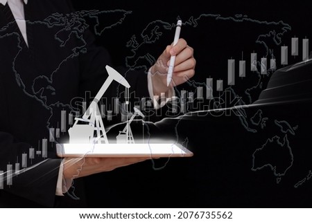 Equipment for pumping oil on a digital screen and graph and indicators of financial charts and map in the hands of a businessman, natural resources stock market concept