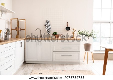 Interior of light kitchen with modern cookware Royalty-Free Stock Photo #2076739735