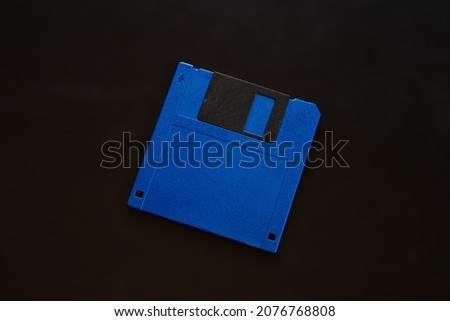 blue floppy disk lies on a black background