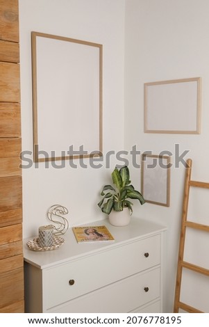 Blank frame hanging on light wall indoors. Space for design