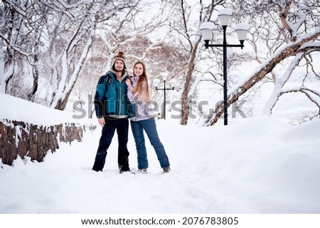 Happy couple in a park at snowy weather