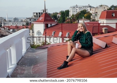 beautiful woman blonde and coffee city from the roof of the house