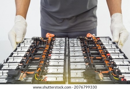Selective focus hands in gloves of expert technicain electric car, EV car while opened A used Lithium-ion car battery before its repair Royalty-Free Stock Photo #2076799330