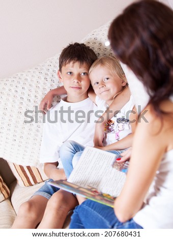 mother reads a book son and daughter