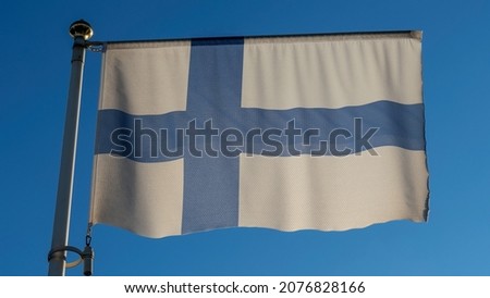 White flag of Finland with big blue cross in front of blue sky with lens flare. Diplomacy concept. International relations. Space for text.