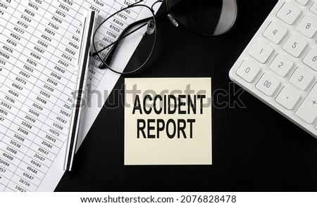 Concept ACCIDENT REPORT message on sticker with glasses,chart and calculator on black background